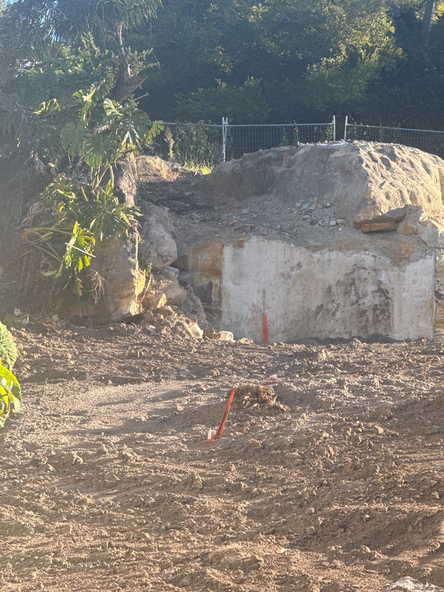 Residential excavation and retaining work beside a landscaped boundary